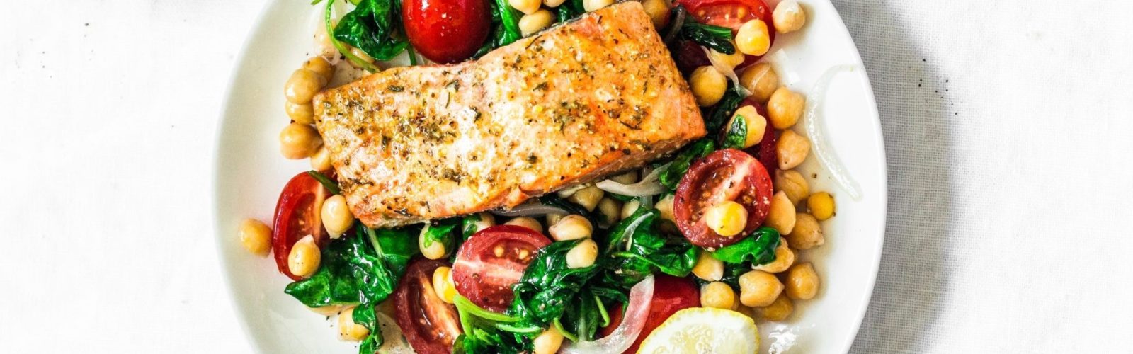 Warm chickpeas, cherry tomatoes, spinach salad with baked salmo