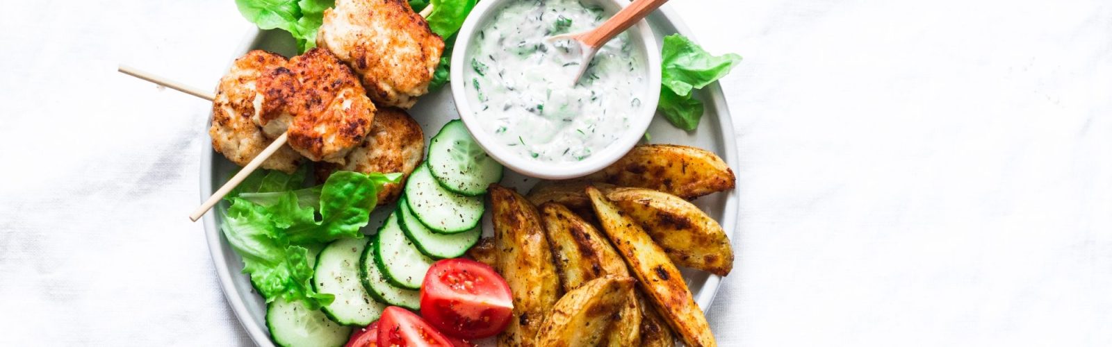 fish kebabs, roasted lemon potatoes, tzatziki sauce and fresh vegetables